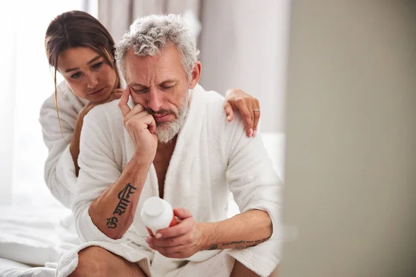 Pensativo guapo adulto hombre leyendo medicina tabletas asignación en moderno apartamento en casa —  Fotos de Stock