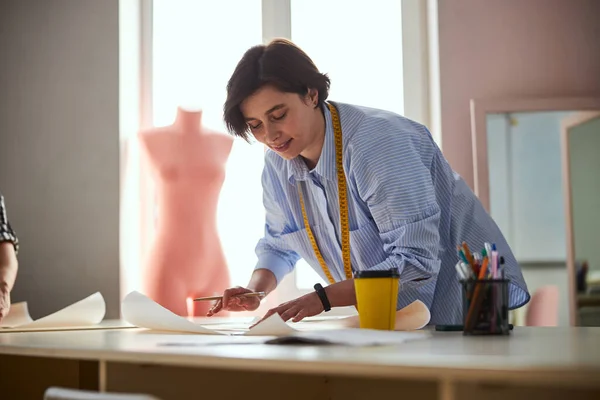 Sastre creando un diseño de vestido en una pieza de papel —  Fotos de Stock