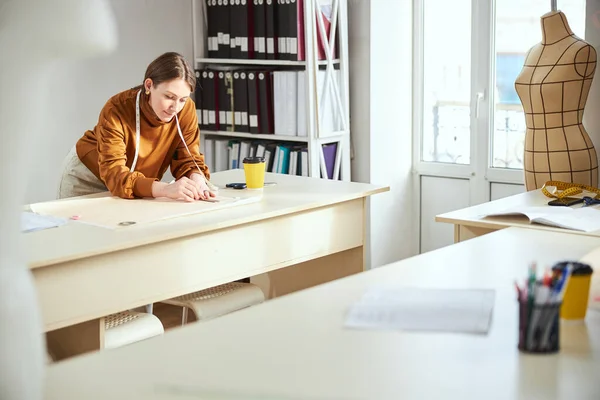 Mujer solitaria cerca de la mesa colocando su boceto sobre papel —  Fotos de Stock