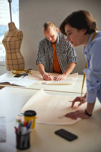 Concentrated man drawing a line on paper — Stock fotografie