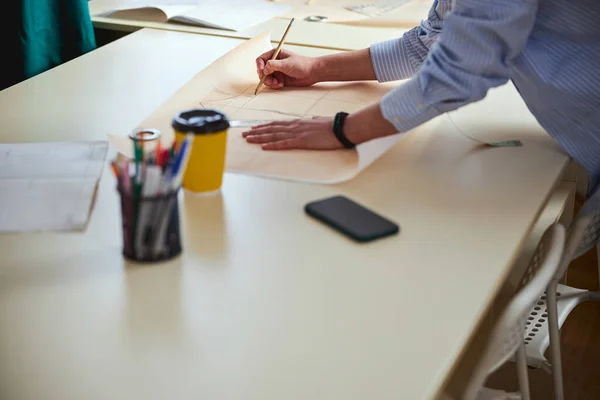 Lápiz en mano del sastre utilizado para dibujar bocetos de ropa — Foto de Stock