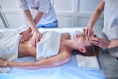 Young pretty lady relaxing at the spa complex procedure in spa cneter
