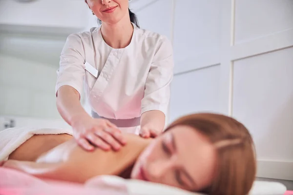 Massage therapeut in wit uniform maken spa behandeling in schoonheidskliniek — Stockfoto