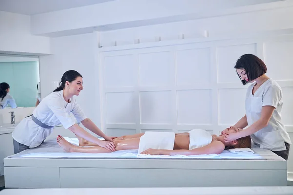 Junge kaukasische Frau mit Handtuch auf dem Körper entspannt sich und ruht sich im Wellnesskomplex in der Schönheitsklinik aus — Stockfoto