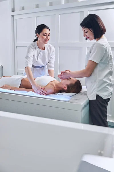 Junge rothaarige Frau liegt auf Massagetisch im Wellness-Salon — Stockfoto