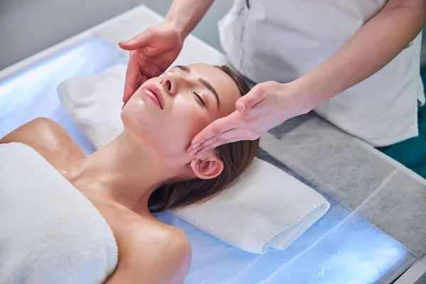 Happy cheerful adorable woman relaxing at the massage therapy in spa resort center — ストック写真