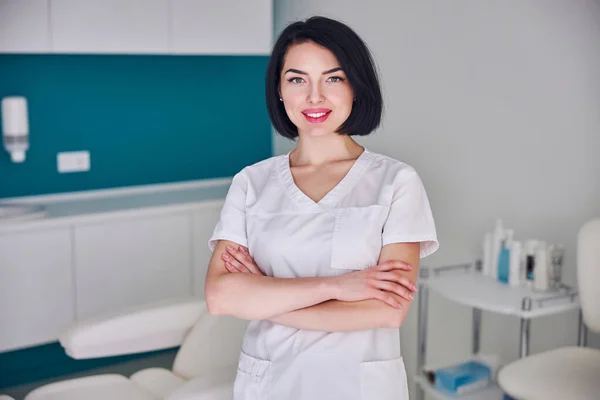 Happy attractive woman with cute smile posing at the camera in medicine center — Stock Photo, Image