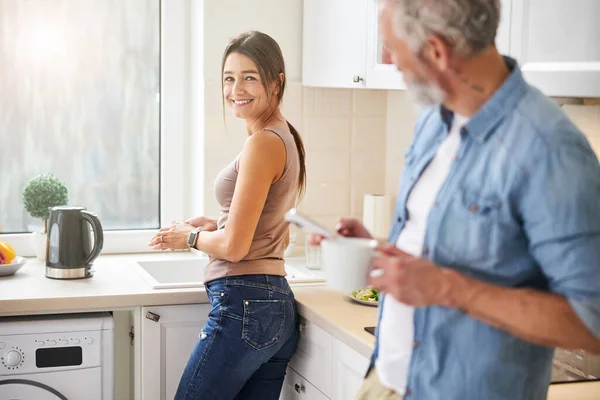 Mulher alegre feliz olhando para o marido na cozinha — Fotografia de Stock