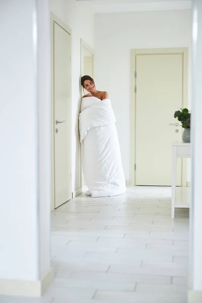 在家里的白色走廊里，一个优雅迷人的女人在镜头前摆出一副笑脸 — 图库照片