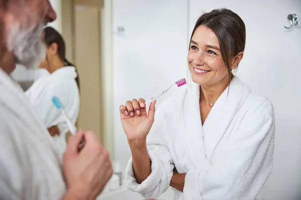 Bájos csinos fiatal nő mosolyog a fürdőszobában a reggeli eljárás — Stock Fotó