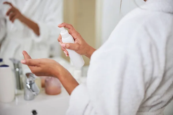 Joven elegante brazos de hermosa dama con spray cosmético en la habitación en el interior — Foto de Stock