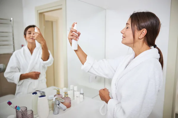 Elegáns gyönyörű nő áll a tükör előtt, miközben a bőrápolás a szobában — Stock Fotó