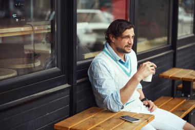 Kafede kahve içen yakışıklı sakallı adam.