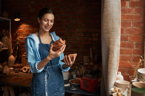 Linda jovem senhora gosta de trabalhar com produtos de barro no estúdio de cerâmica — Fotografia de Stock