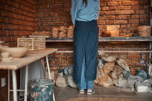 陶器の居心地の良いワークショップで陶器製品を絞る美しいエレガントな若い陶芸家 — ストック写真