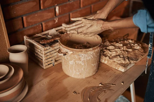 Güzel zanaatkar kadın kolları çömlek atölyesinde toprak malzemesi ile bir şey şekillendiriyor. — Stok fotoğraf