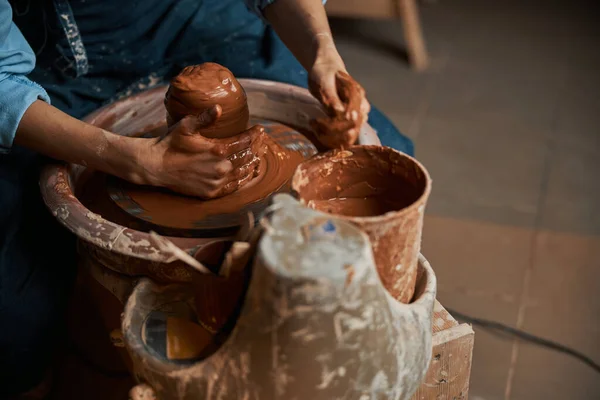 Ismeretlen kézműves nő préselő cserépáru barna sár a kerámia kerék a művészeti stúdióban — Stock Fotó