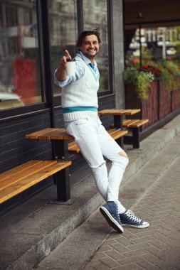 Kahveyle birlikte kağıt bardak alan neşeli bir erkek.