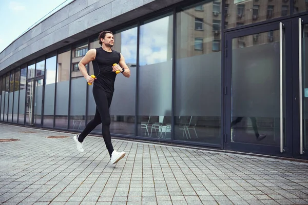 Young active man running down the street — Stock Photo, Image