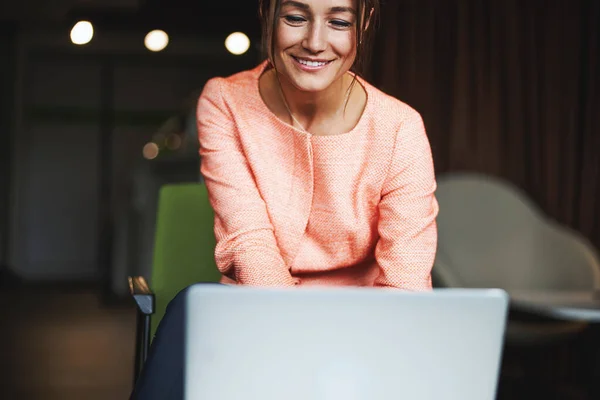 Felice donna ansiosa attraente in giacca rosa che lavora online in camera al chiuso — Foto Stock