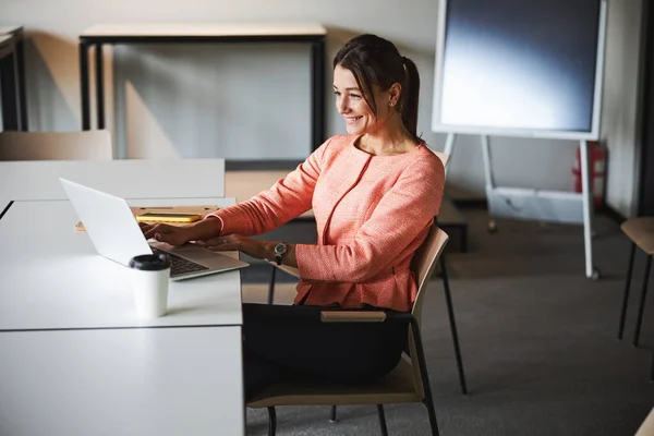 Jeune spécialiste du marketing internet femme caucasienne attrayante regardant à l'écran de son netbook — Photo