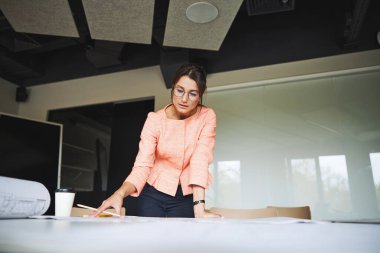 Young successful pretty lady in glasses working in the modern luxury office