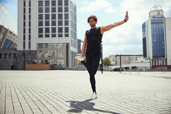 Young male person keeping balance on one foot — стоковое фото