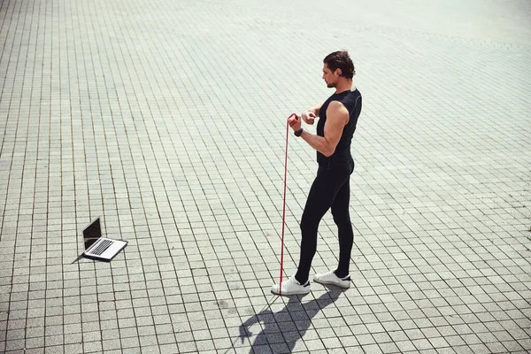 Strong male person tighten the elastic expander — Stock Photo, Image