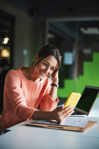 Young attractive Caucasian business lady watching something on smartphone in the meeting room — Φωτογραφία Αρχείου