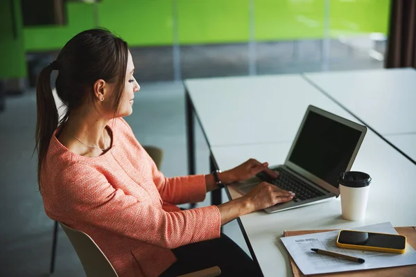 Beautiful young attractive Caucasian woman entrepreneur looking to the screen of her netbook in the cozy office — Stockfoto