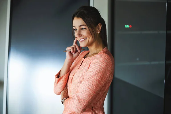 Charming young woman internet marketing specialist in stylish formal wear standing in the luxury counsulting room — Stockfoto