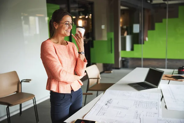 Young cheerful brunette female business consultant in glasses working in the modern bright start-up office — Stockfoto