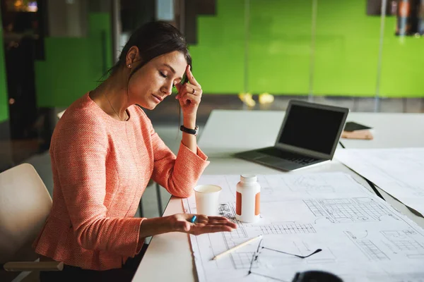 Beautiful Caucasian business analyst feeling headache while working with report in the office — Fotografia de Stock