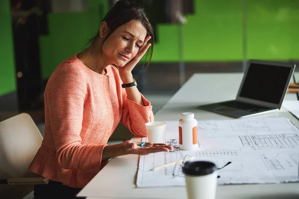 Young Caucasian female business analyst with close eyes getting sick in co-working space — стокове фото