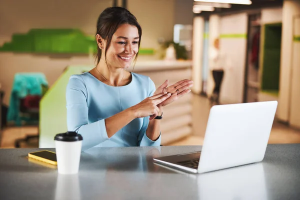 Young Caucasian teacher working with student online while gesturing at the camera of her laptop — стокове фото