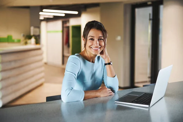 Young Caucasian female internet marketing specialist working at the laptop while surfing internet in modern interior workroom — Photo