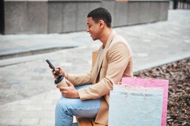 Gelir mesajını okuyan mutlu genç adam