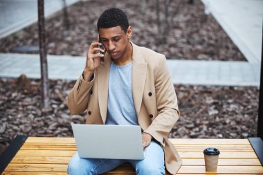 Ciddi esmer adam konuşma sırasında verileri kontrol ediyor