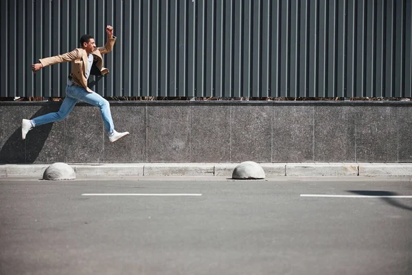 Happy dark-skinned male running home from office — Stock Photo, Image