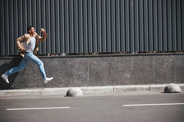 Молодой активный человек бежит в свой офис — стоковое фото