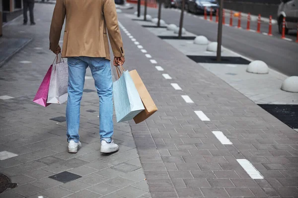 Foto focada no homem que carrega sacos de compras — Fotografia de Stock
