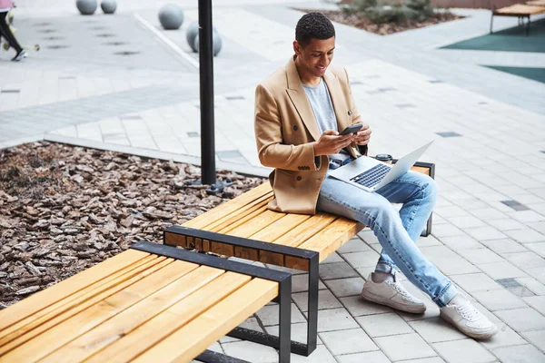 Молодой брюнетка мужчина читает сообщение на смартфоне — стоковое фото