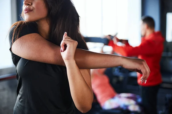 Hermosa joven mujer se está calentando en el gimnasio —  Fotos de Stock