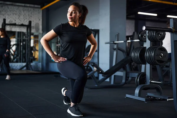 Mujer joven enérgica haciendo entrenamiento piernas en el gimnasio — Foto de Stock