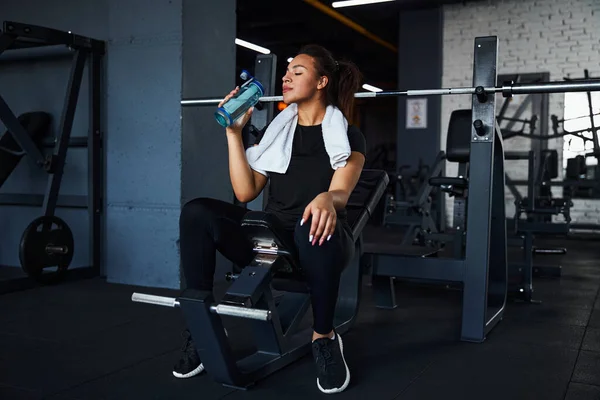 Lycklig kvinna släcka törst efter träning i gym — Stockfoto