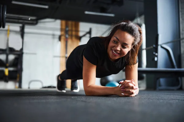 Alegre mujer joven núcleo de entrenamiento en el gimnasio — Foto de Stock