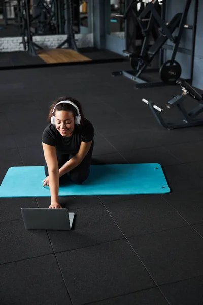 Mujer feliz comenzando el entrenamiento en línea en el gimnasio — Foto de Stock