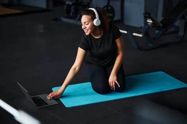 Mujer feliz empezando a entrenar con portátil en el gimnasio — Foto de Stock