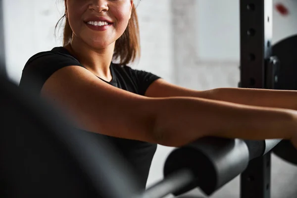 Vrolijke jonge vrouw uit te werken met zware apparatuur — Stockfoto