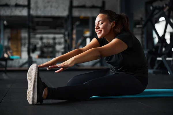 Glada ung kvinna tränar flexibilitet i gymmet — Stockfoto